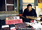 The man is making Tsatsa, a small sculpture of Buddha.