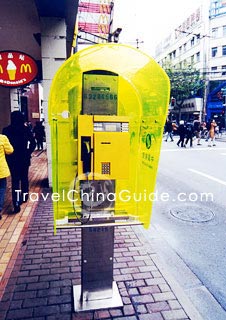 A beautiful telephone kiosk in the street.