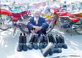 A Uygur elder is selling boots in the Kashgar Bazaar