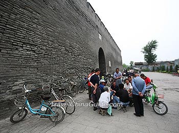 Local people play card under the City Wall 