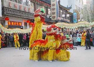 The lion dancers are imitating the happy lion family vividly.