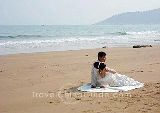 A new couple is taking photos on the beautiful seashore.