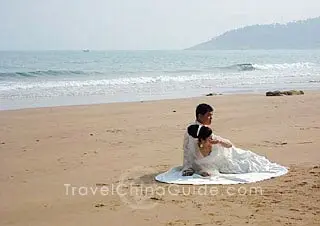 A new couple is taking photos on the beautiful seashore.