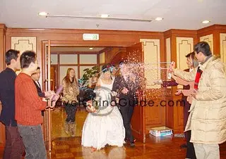 Friends spray colorful flowers to the newly-wed.