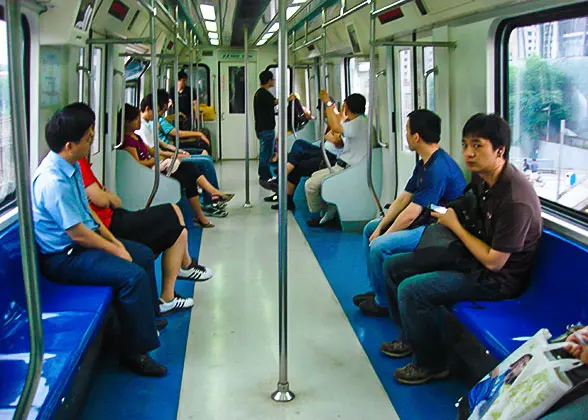 Students play online games inside a subway train in Beijing