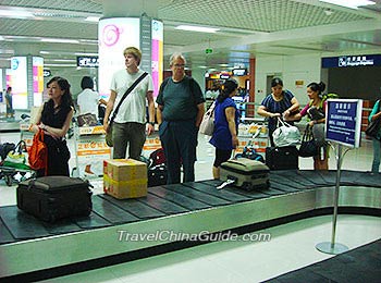 Passengers wait to take their baggages at the airport.