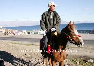 A man ride a horse along the lake