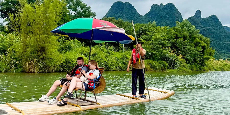 Tourists Experiencing Bamboo Rafting in Hot July