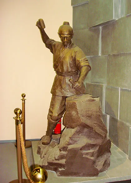 A laborer chiseling stone