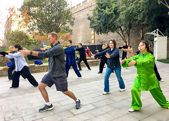 Tourists and locals practicing Tai Chi